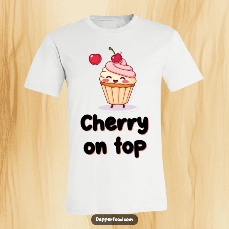 Funny T-shirt graphic of a blushing cupcake character adorably tossing a cherry into the air with a happy, playful demeanor.